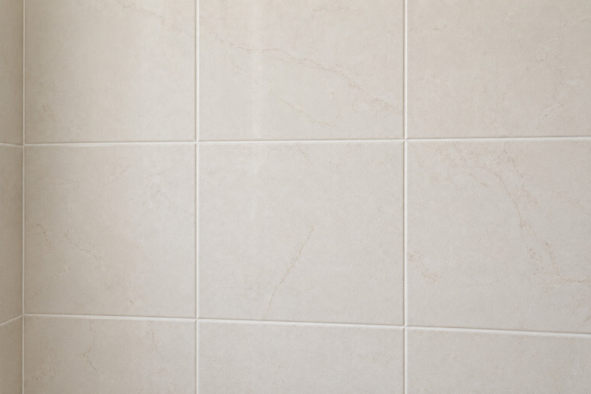 Pale ceramic bathroom wall tile with clean white grout